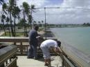 During the early morning set up, Uris, WP4NSF (left), and Héctor, WP3ZZ, mount the Buddipole to the walkway railing overlooking the Caribbean.