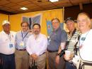 The IARU booth is a hotbed of activity. Here, IARU President Tim Ellam, VE6SH (second from left), meets with Gustavo de Faria Franco, PT2ADM (far left); IARU Region 2 Secretary Ramon Santoyo, XE1KK (to Ellam's right); Daniel Lamoureux, VE2KA; Dario Jurado, HP1DJ, and Orlando Perez Filho, PT2OP. [S. Khrystyne Keane, K1SFA, Photo]