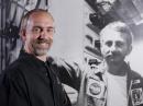 Richard stands next to a poster of his father Owen at the Johnson Space Center. [Andrew Yates, Photo]