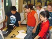 Studentas in a group talking on a radio set up inside.